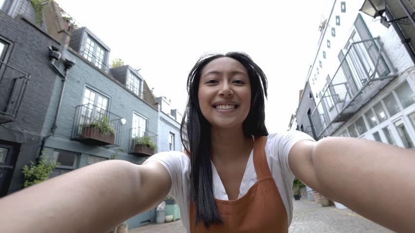 Happy tourist taking selfies in a picturesque london street