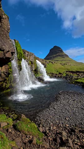 Witness the majestic Kirkjufell mountain surrounded by lush green slopes and crystal-clear waterfalls. This breathtaking location in Iceland offers unparalleled natural beauty and tranquility.