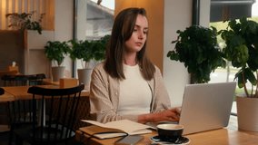 European woman concentrated busy in cafeteria manager analyzing data girl female studying in cafe remote write preparing to exams writing notes with laptop net working businesswoman business distant - Powered by Shutterstock - Get 15% off with code: PIKWIZARD15