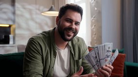 Happy smiling rich joyful Caucasian business man male guy homeowner client businessman customer sitting sofa winning lottery bet holding cash money dollars stack looking at camera smile at home wealth - Powered by Shutterstock - Get 15% off with code: PIKWIZARD15