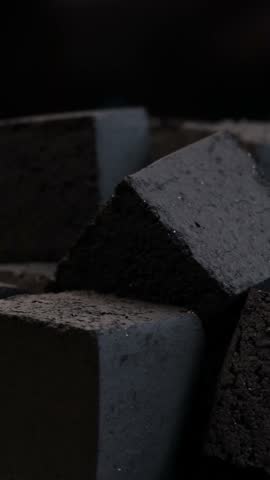 vertical video showing rotating hookah coal cubes in dark atmosphere highlighting rough textured surfaces and sharp edges concept of hookah lounge tobacco shop smoking accessory