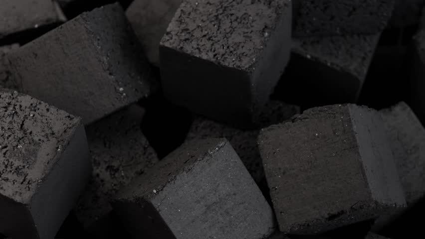 black coal cubes spin in circle on dark background showing detailed rough surfaces and solid form concept of hookah lounge tobacco shop smoking accessory