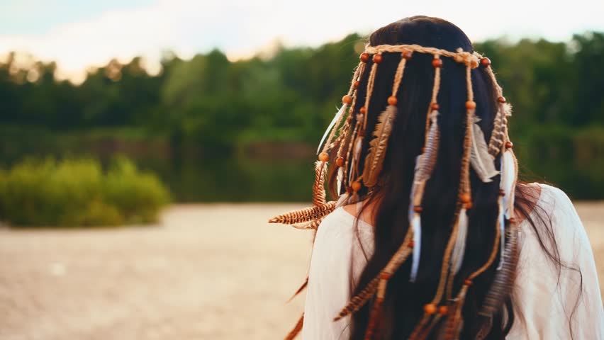 unrecognizable person happy girl in white dress clothes bohemian style long dark hair decorated headband with feathers beads stylish boho hippie. Woman summer enjoying freedom nature back rear view.