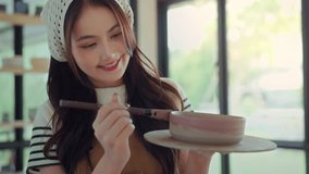 Asian woman artist painting handmade ceramic product in pottery studio – creative process of decorating sculpture with brush for small business, art workshop, and modern craft design startup - Powered by Shutterstock - Get 15% off with code: PIKWIZARD15