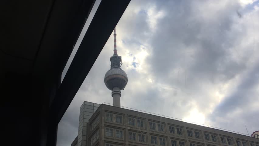 The video of Berlin Alexanderplatz captured through a glass inside the tram during a travel around the city center. There was the berlin tower and socialist buildings from post second world war era.