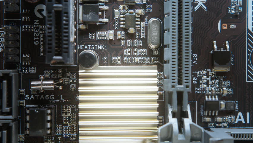Close-up view of a computer motherboard during maintenance, highlighting heatsink and capacitors for possible repair or replacement.