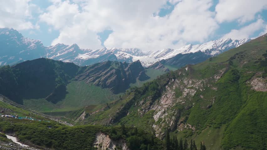 Beautiful view of Himalaya mountain range as seen from Beas Kund Trek in Himachal Pradesh, India. Mountains and clouds, summer landscape. Travel and holidays background.