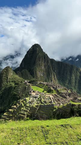 A breathtaking view of Machu Picchu surrounded by mist and towering peaks — ancient stonework meets the clouds in this beautiful scenery in the Andes mountains.