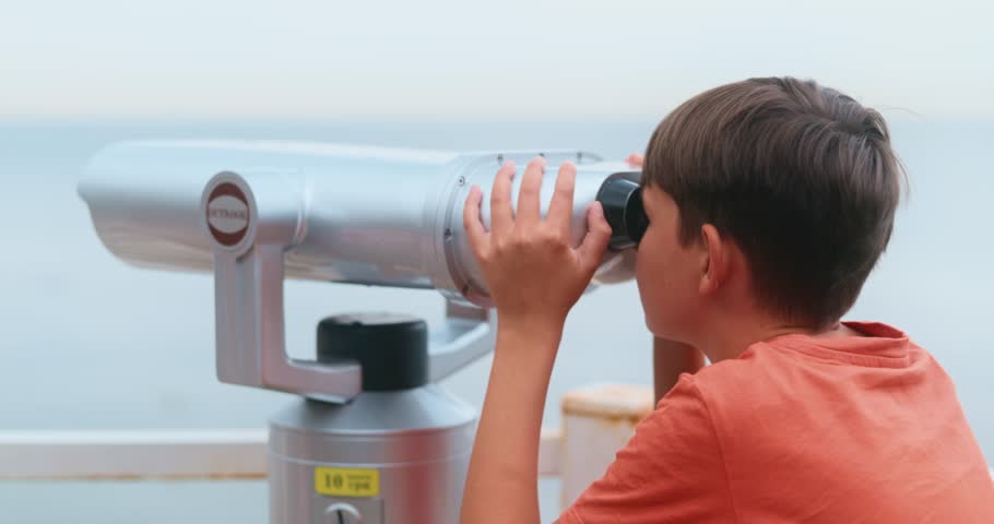 Child Using Binoculars at Scenic Overlook by the Sea