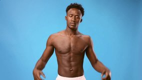 Young African American man flexing muscles against a blue background - Powered by Shutterstock - Get 15% off with code: PIKWIZARD15
