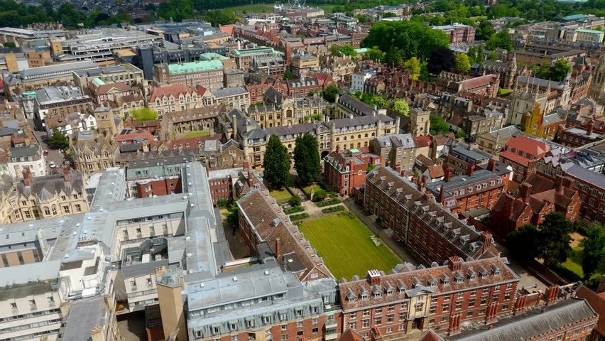 High angle view of Cambridge University campus with historic colleges, buildings, green courtyards and surrounding urban landscape