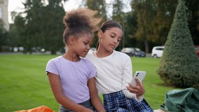 Multiethnic children little girls African American Latino schoolgirls friends sisters pupils school students teens using mobile phone together kids blogging addict smartphone play game outdoors city - Powered by Shutterstock - Get 15% off with code: PIKWIZARD15