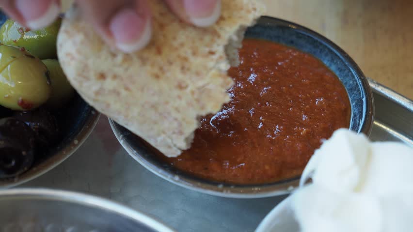 Dipping bread into savory sauce at local eatery in the afternoon
