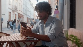 Arabian latino man guy visitor cafe buyer happy customer businessman drink coffee outdoor using mobile phone online shopping outside Indian male tourist showing thumb up approve travel app smartphone - Powered by Shutterstock - Get 15% off with code: PIKWIZARD15