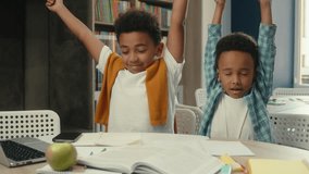 African American little boys ethnic children siblings pupils students schoolboys writing exercise studying at desk primary school education tired kids boring study yawn exhausted stretch hands sleep - Powered by Shutterstock - Get 15% off with code: PIKWIZARD15