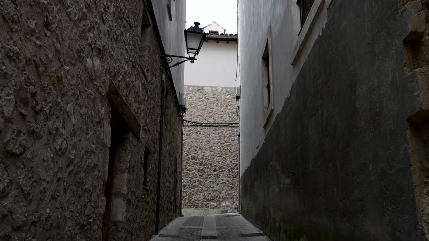 CUENCA, SPAIN - A view down a medieval stone alley in the historic heart of this UNESCO city. The old, textured walls evoke a sense of history and mystery.