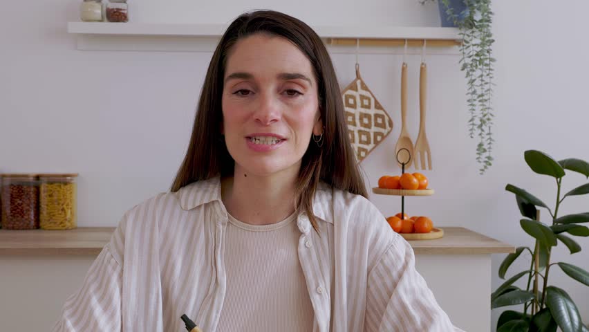 POV or portrait screen view of mid adult woman talking on laptop computer video call in the kitchen at home. Business people and virtual conference concept. 