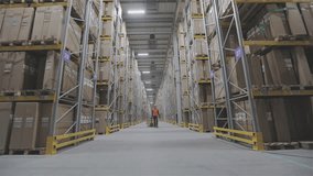A warehouse worker is carrying cardboard boxes of products through the warehouse. Warehouse accounting and product picking. Working in a large modern multi-level smart warehouse inside - Powered by Shutterstock - Get 15% off with code: PIKWIZARD15