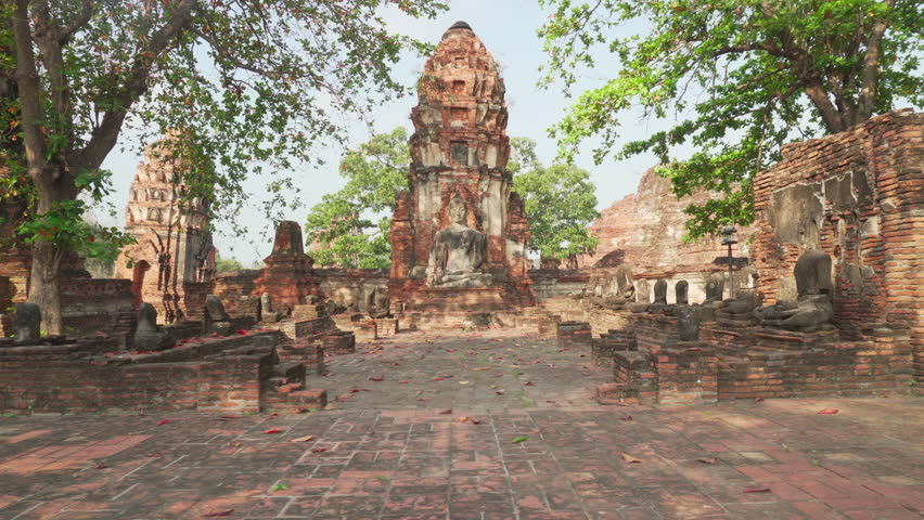 Buddha statue among ruins of the Wat Mahathat in Ayutthaya, Thailand. Amazing view of the Buddhist temple in the ancient city of the Ayutthaya Kingdom (Siam). Thailand is a popular tourist destination