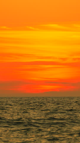Sunset Ocean Sky Vivid orange sunset over calm ocean at dusk, showcasing atmospheric beauty.