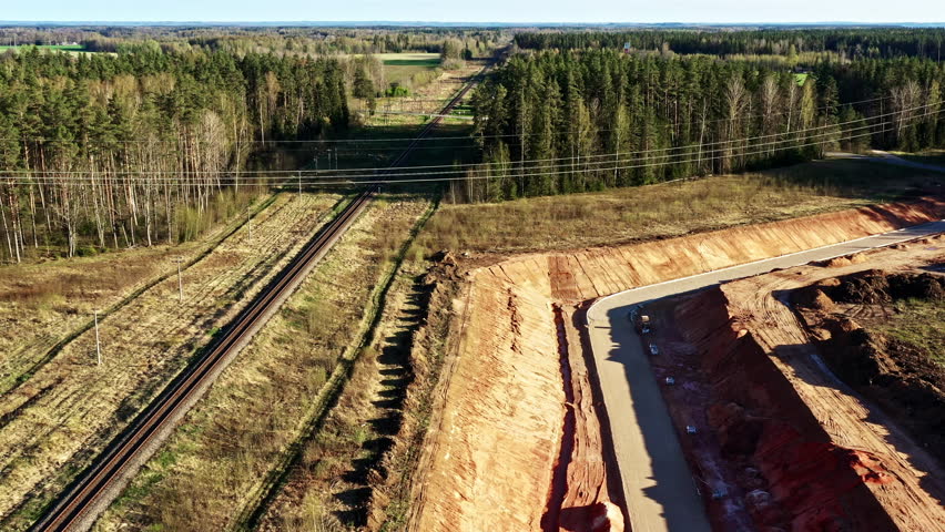 Large scale railway and road construction site with cleared soil in aerial view