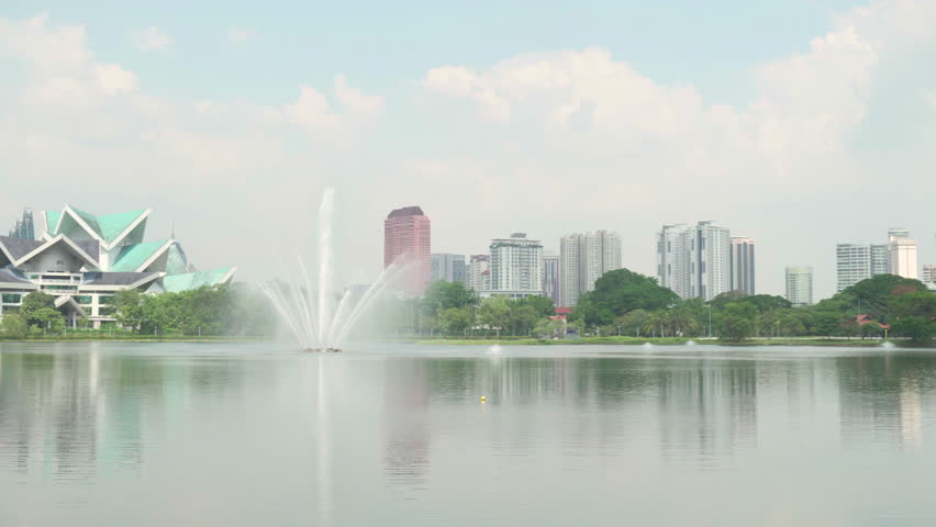 Awesome Kuala Lumpur skyline. Panning motion. Amazing view of scenic lake in a city park of Kuala Lumpur, Malaysia. Beautiful cityscape. Kuala Lumpur is a popular tourist destination of Asia.