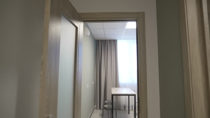 Compact kitchen features small table tidy cabinets and contemporary induction stove. Organized space supports comfortable daily cooking