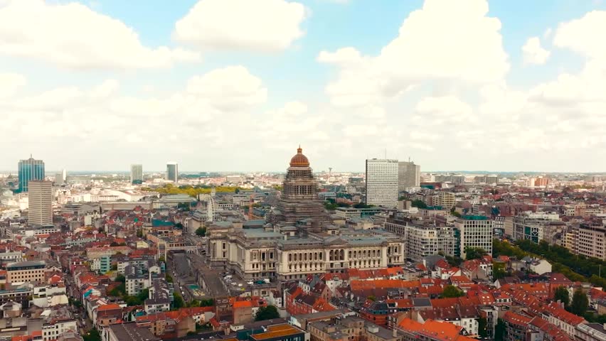 Aerial drone video of the Court of justice or otherwise known as palace of Justice in Brussels, Belgium, Europe during a sunny day with small medieval historic building and cobblestone road around it.