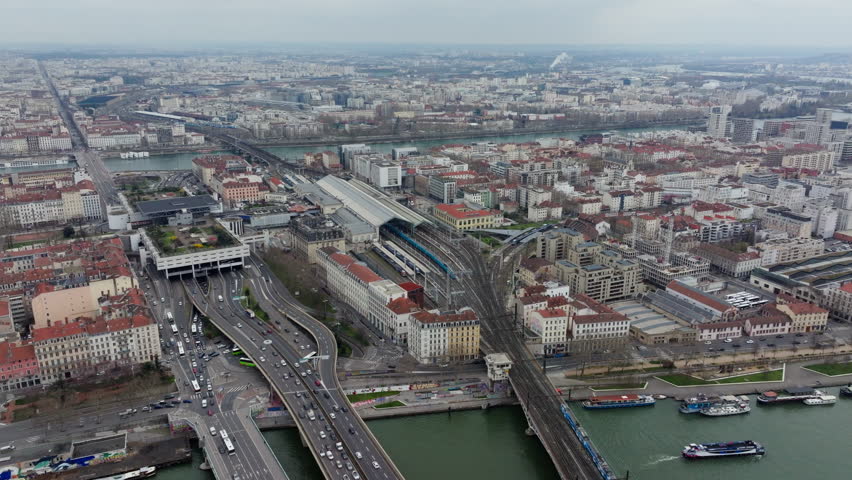Aerial view of Lyon train station, highway interchange, and surrounding urban landscape with intense car traffic and bridges over Saone river