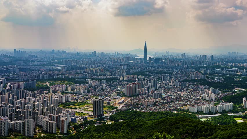 A wide-angle panning timelapse sweeps across the immense cityscape of Seoul, South Korea, revealing the sprawling urban landscape with the famous Lotte World Tower at its heart.