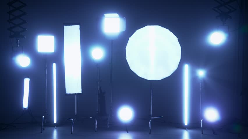Professional shooting pavilion with lighting equipment. The process of preparing for the shooting of a music video. Cameraman and crew in Backstage. Slow motion