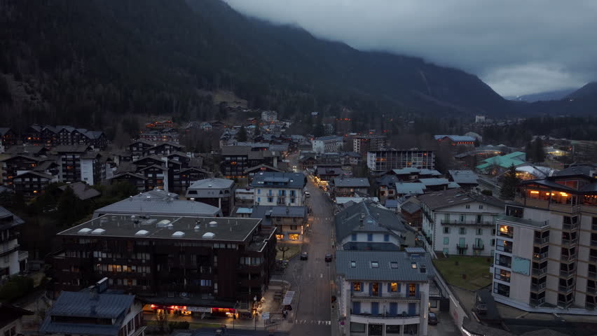 Chamonix town lights up at dusk, nestled in the French Alps near Mont Blanc, offering a tranquil mountain view in a major tourist destination