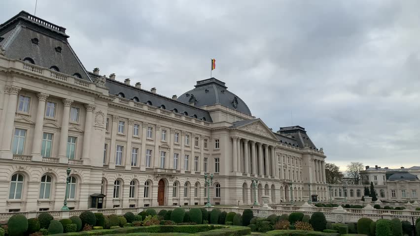 Belgian flag is waiving on top of the Royal Palace of Brussels. It is the official palace of the Belgian Royal family in the city centre. Front facade. Bruxelles, Brussels capital region, Belgium