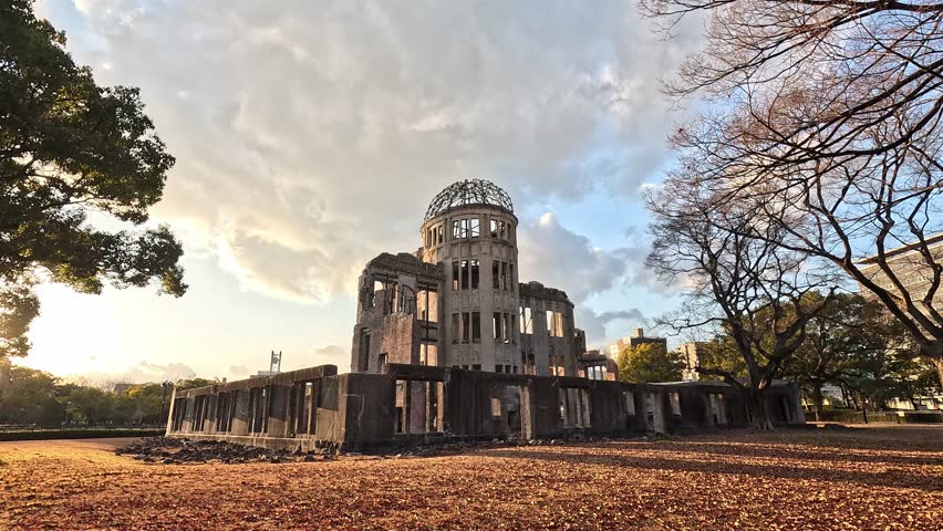 Hiroshima Peace Memorial Dome at Sunset with Bare Winter Trees and Fallen Leaves in Foreground in Hiroshima Japan, a Symbol of Remembrance and Hope