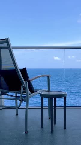 Tranquil open sea view from cruise ship balcony with blue sky and sun, vertical view