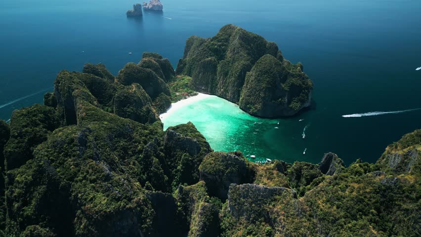 Stunning drone shot of Maya Bay s turquoise lagoon surrounded by dramatic limestone cliffs. Located in Krabi, Thailand, this iconic spot is ideal for travel, tourism, and exotic promos.