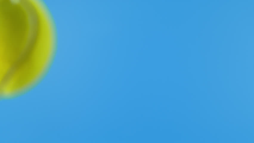 Super Slow Motion of Tennis Ball Hitting Camera on Blue Screen, 1000 fps.