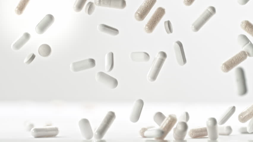 Super Slow Motion of Pills Falling on White Background at 1000fps.