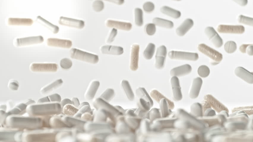 Super Slow Motion of Pills Falling on White Background at 1000fps.