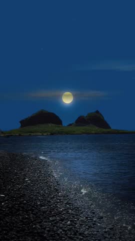 Full moon shines over calm water and a dark pebble beach, with two silhouetted islands in the distance. A tranquil, minimalist night scene under a starry sky.
