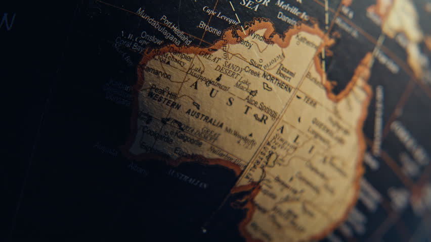 Australia mainland marked globe surrounded black oceans surface closeup. Yellow continent illustrated at vintage planet model indoors. Macro view geography topography elements placed on Earth sphere.