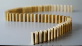 Finger pushing domino line destroying wavy shape on light table surface closeup. Unrecognizable man activating chain reaction indoors. Falling toy blocks crash one by one showing energy and direction. - Powered by Shutterstock - Get 15% off with code: PIKWIZARD15