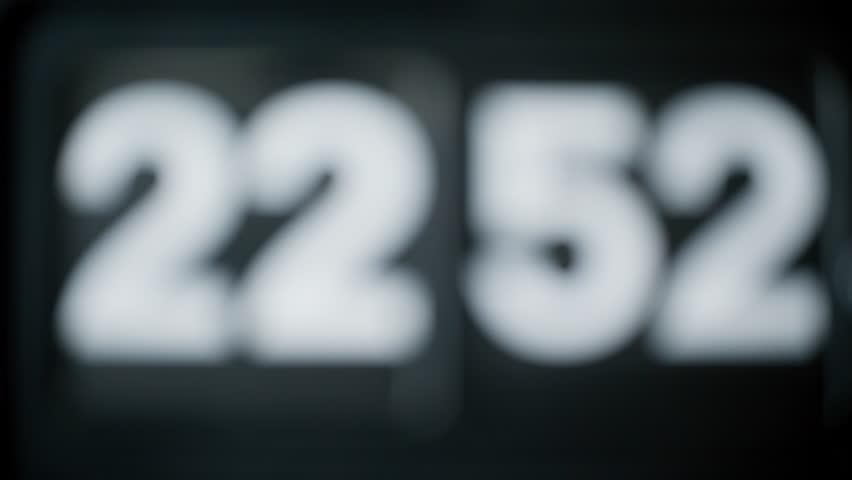 Retro flip clock switching time closeup. Macro view numbers changing in mechanical rhythm at black background. Mechanical device rotating panels showing silent progress in space. Vintage mechanism.