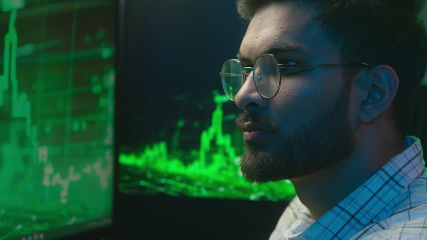 Scared worried Arabian Indian man nervous male shocked confused guy businessman business in office neon programmer coder trader broker problem trouble trading chart graph lose failure crypto currency