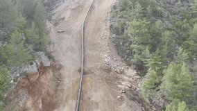 mountain construction drone view coniferous forest 4k. construction of gas pipelines in the mountains - Powered by Shutterstock - Get 15% off with code: PIKWIZARD15