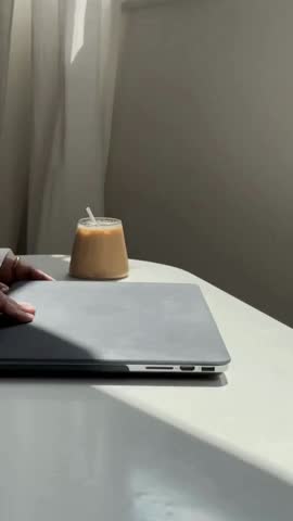 An aesthetic video capturing hands typing on a laptop in a cozy, well-lit workspace. With a minimalist setup and soft tones, this footage reflects modern remote work, productivity.