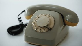 Hands using stationary telephone for communication at home closeup. Unrecognizable man picking up receiver retro phone dialing number on rotary mechanism. Vintage mechanical technology of 90s indoors. - Powered by Shutterstock - Get 15% off with code: PIKWIZARD15