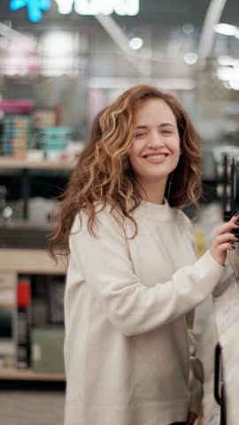 Woman choosing microwave oven in electronics store in slow motion