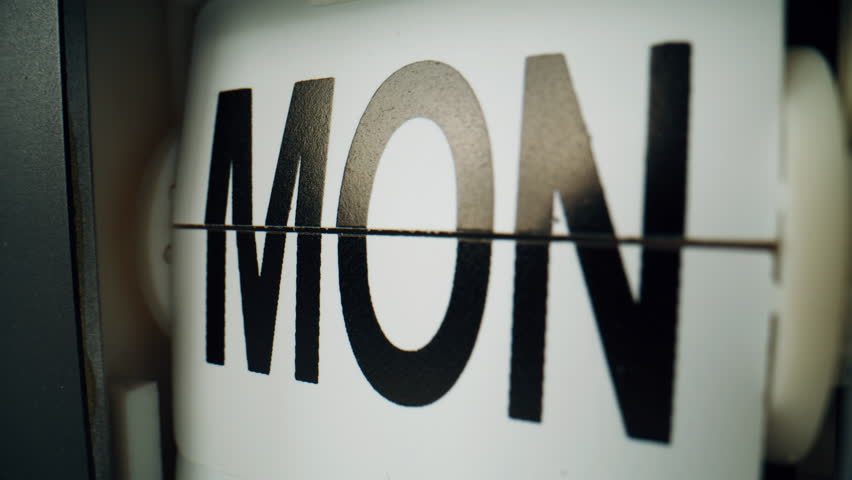 Closeup clock calendar flipping indoors. Macro view days names changing at white plastic panels indoors. Date ticking on vintage electrical timepiece. Retro flipclock measuring time flow. Timekeeper.