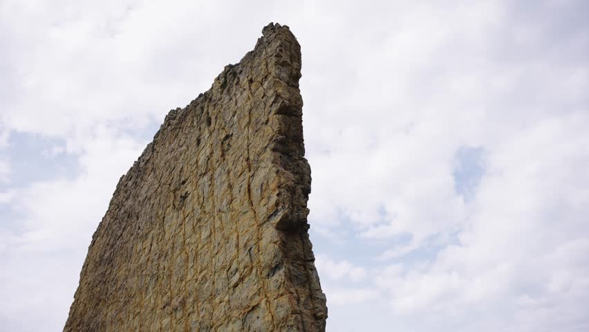 Vertical Sea Cliff Column Dominating The Pebble Beach Landscape
